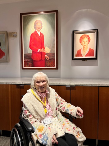 Alice Hawks smiling in front of Betty Crocker portraits on the wall